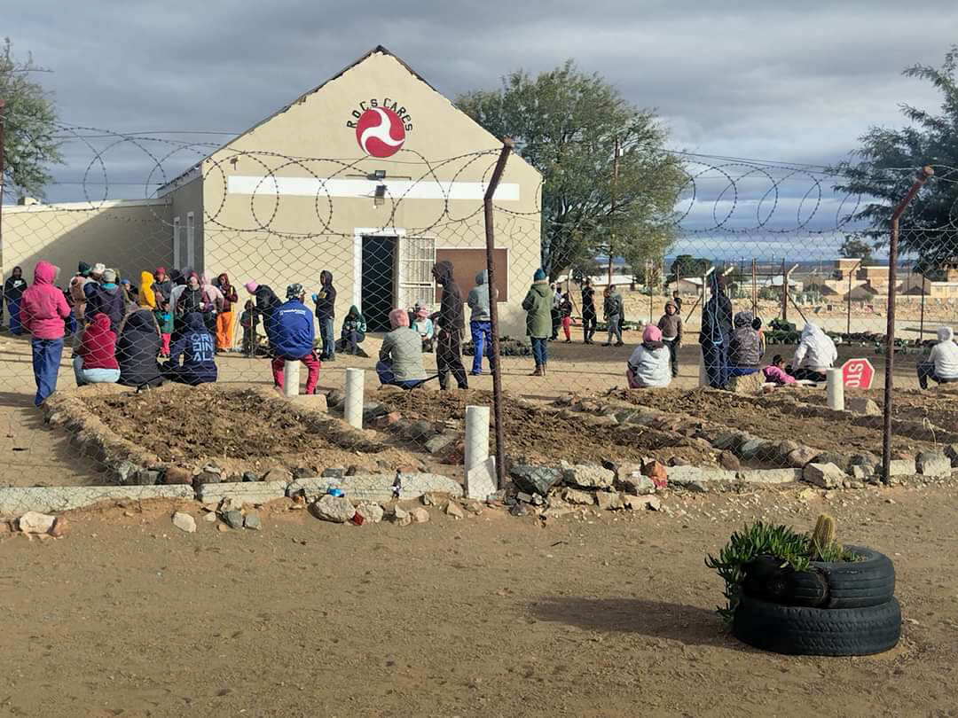 Community members gathering outside ROCS community center on a cloudy day
